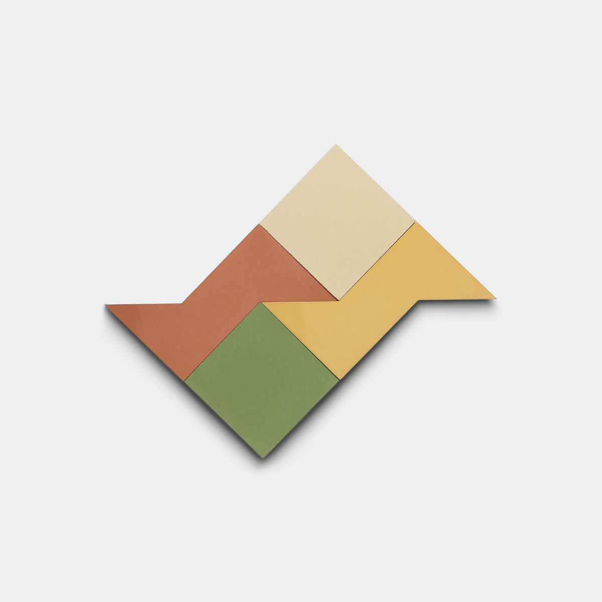 The Manolo Set Four, Sample by Zia Tile features terracotta, beige, yellow, and green geometric shapes arranged in a zigzag on white, echoing the vibrant handmade tile designs characteristic of the brand.