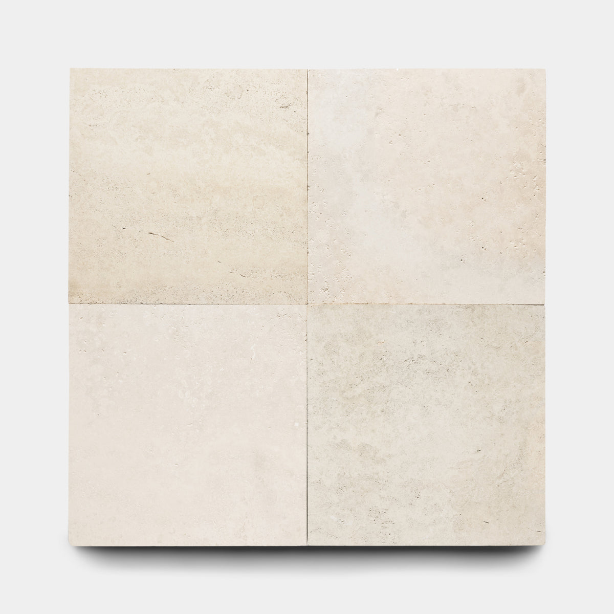 Four Mesa 24x24 tiles by Zia Tile, arranged in a 2x2 grid, display subtle natural texture and slight color variation in beige Cantera stone against a plain white background.