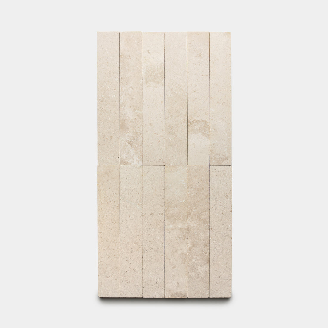 Mesa 2x12 tiles by Zia Tile in beige are arranged vertically in two rows on a white background, creating a clean geometric pattern.