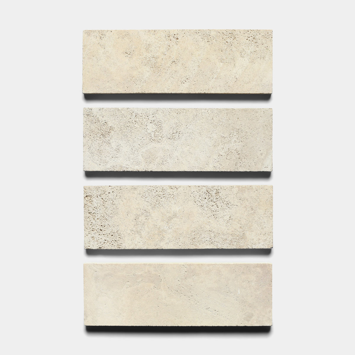 Four rectangular Mesa 4x12 tiles by Zia Tile are arranged vertically on a white background, each beige tile evenly spaced and showing the distinct textures of natural volcanic stone.
