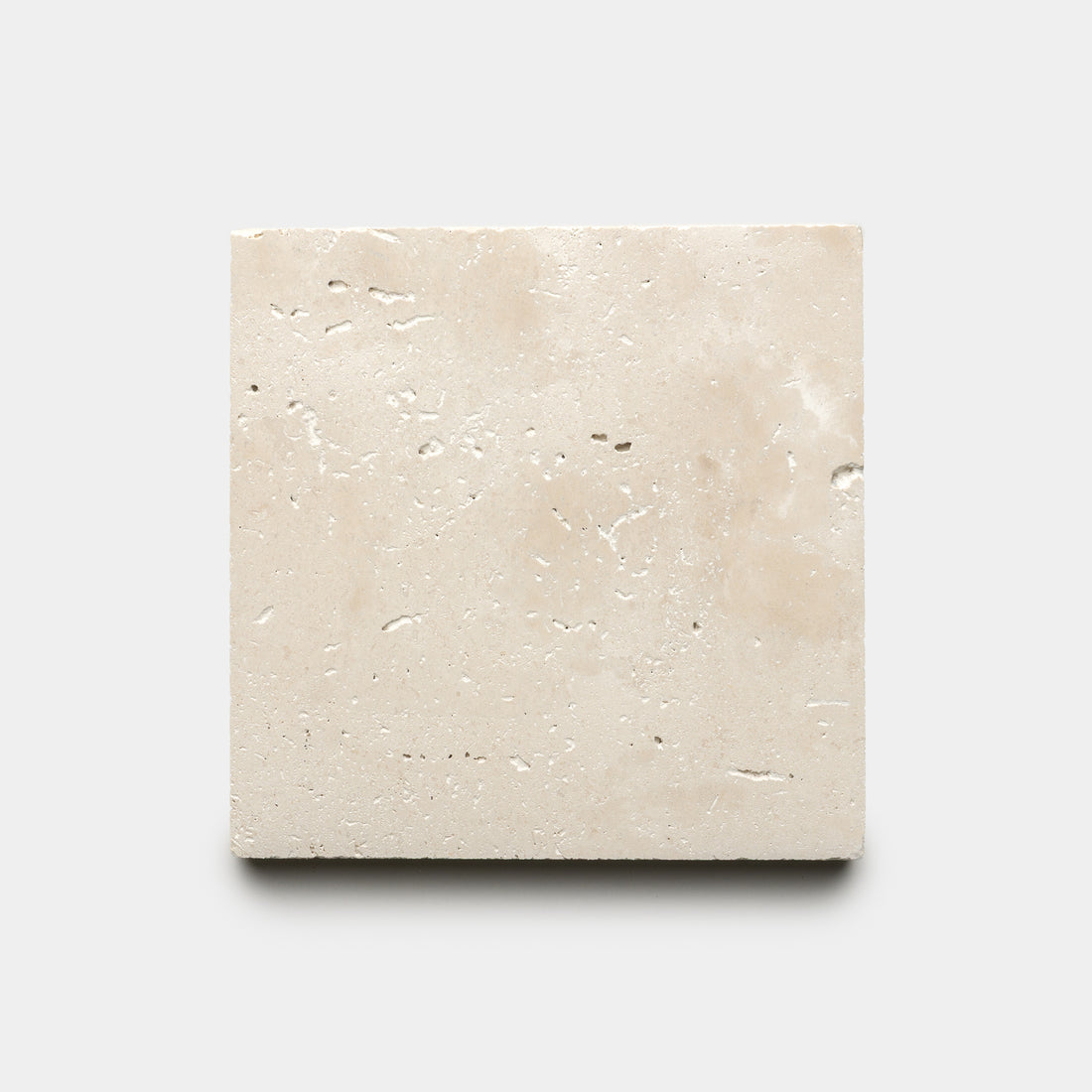 The Mesa 6x6 by Zia Tile is a single square beige tile featuring a textured surface with small natural holes, shown against a plain light gray background.