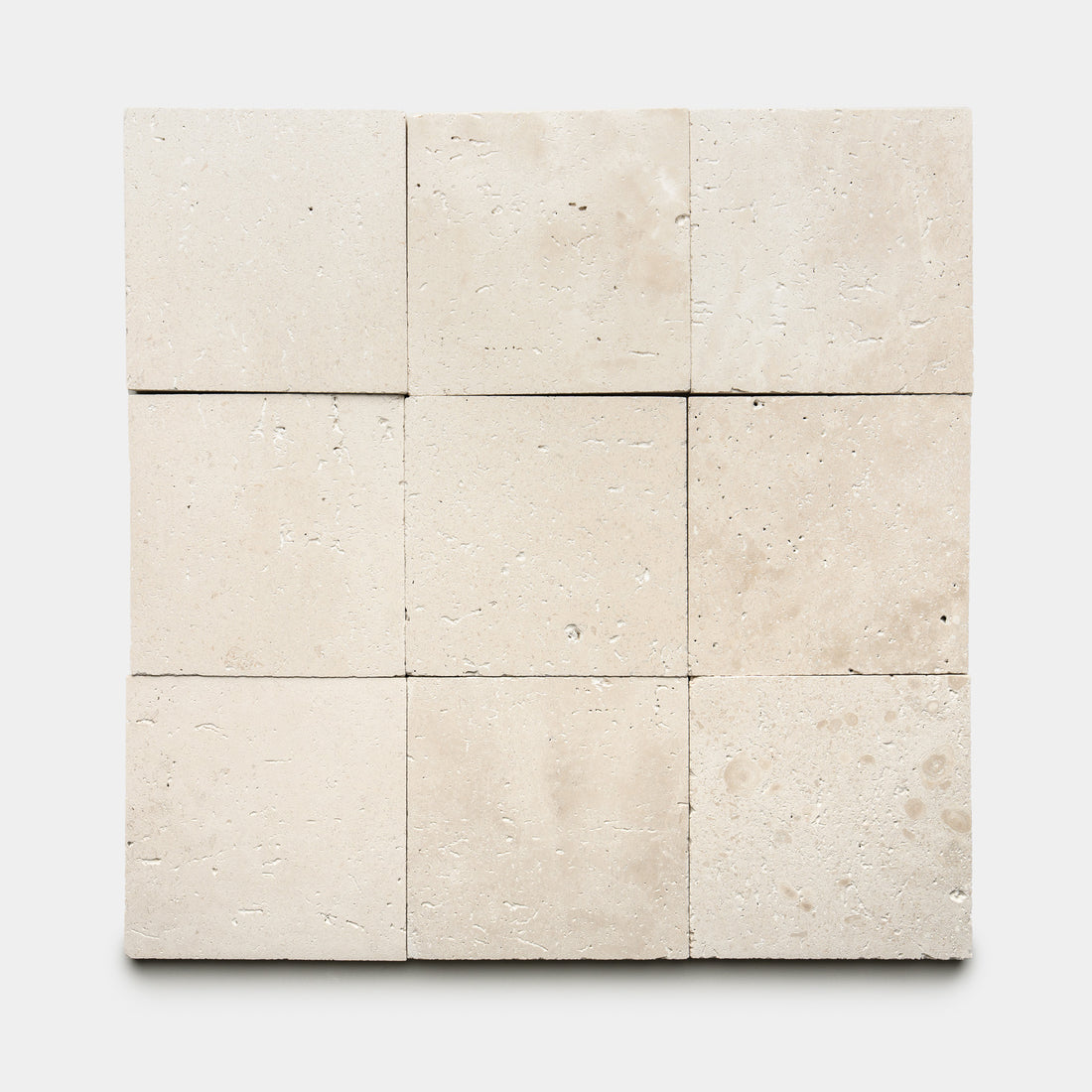 Nine Mesa 6x6 tiles by Zia Tile are arranged in a 3x3 grid on a white background. The beige tiles feature a natural, subtly textured surface with gentle variations and small pores.