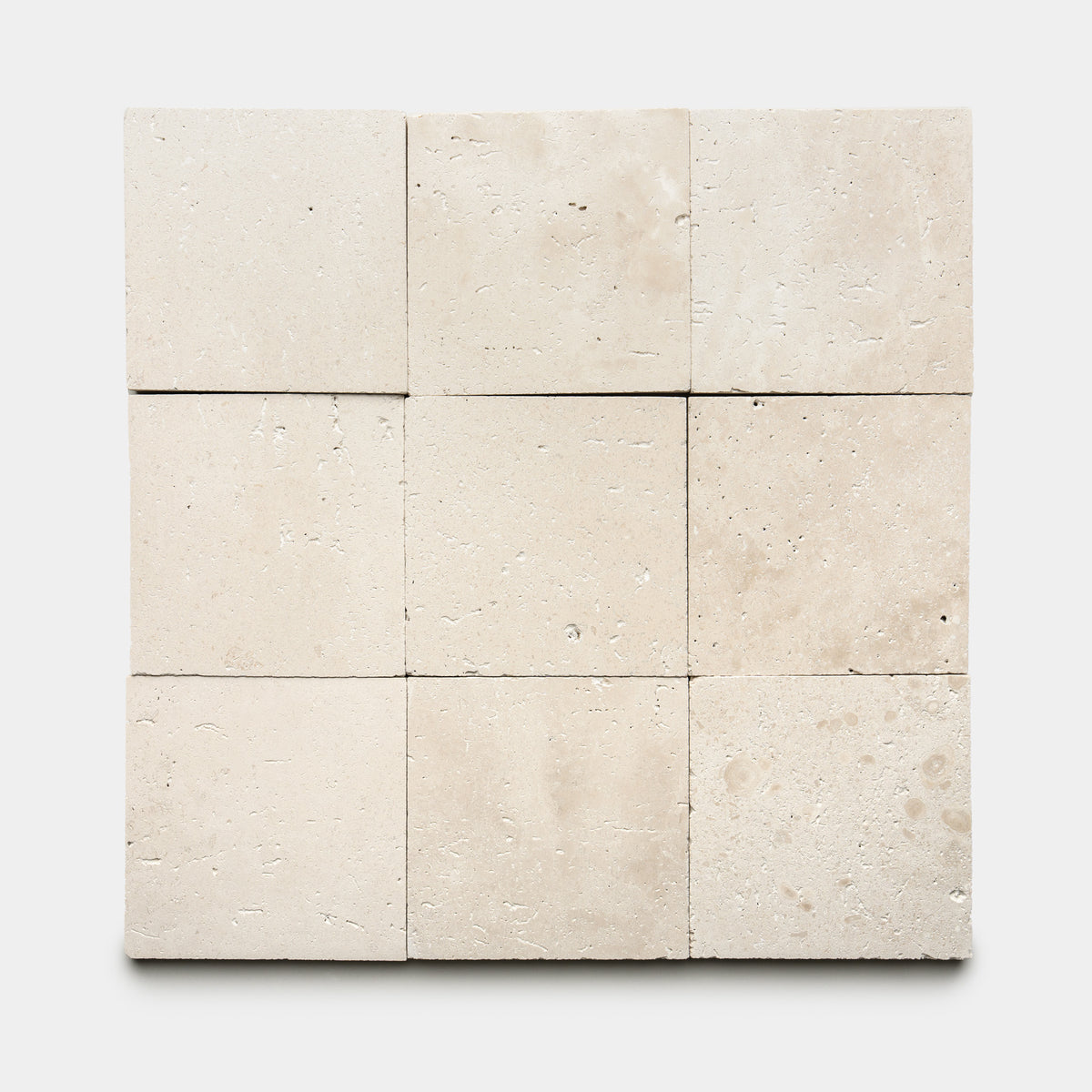 Nine Mesa 6x6 tiles by Zia Tile are arranged in a 3x3 grid on a white background. The beige tiles feature a natural, subtly textured surface with gentle variations and small pores.