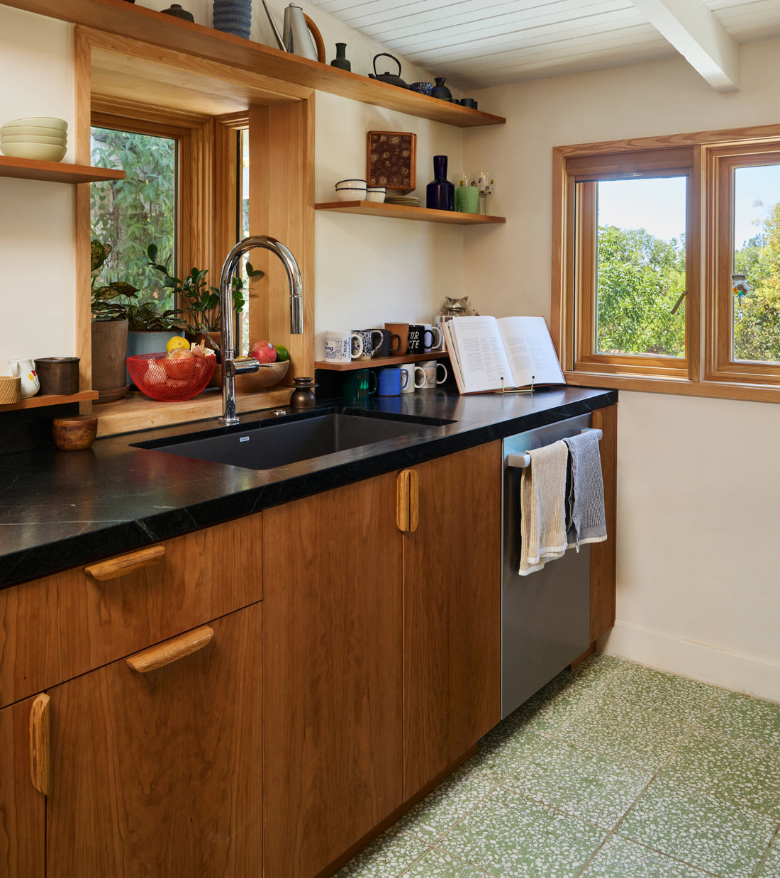 Kitchen with wood cabinets, black countertops, and green patterned Mesquite 12x12 cement tile flooring.