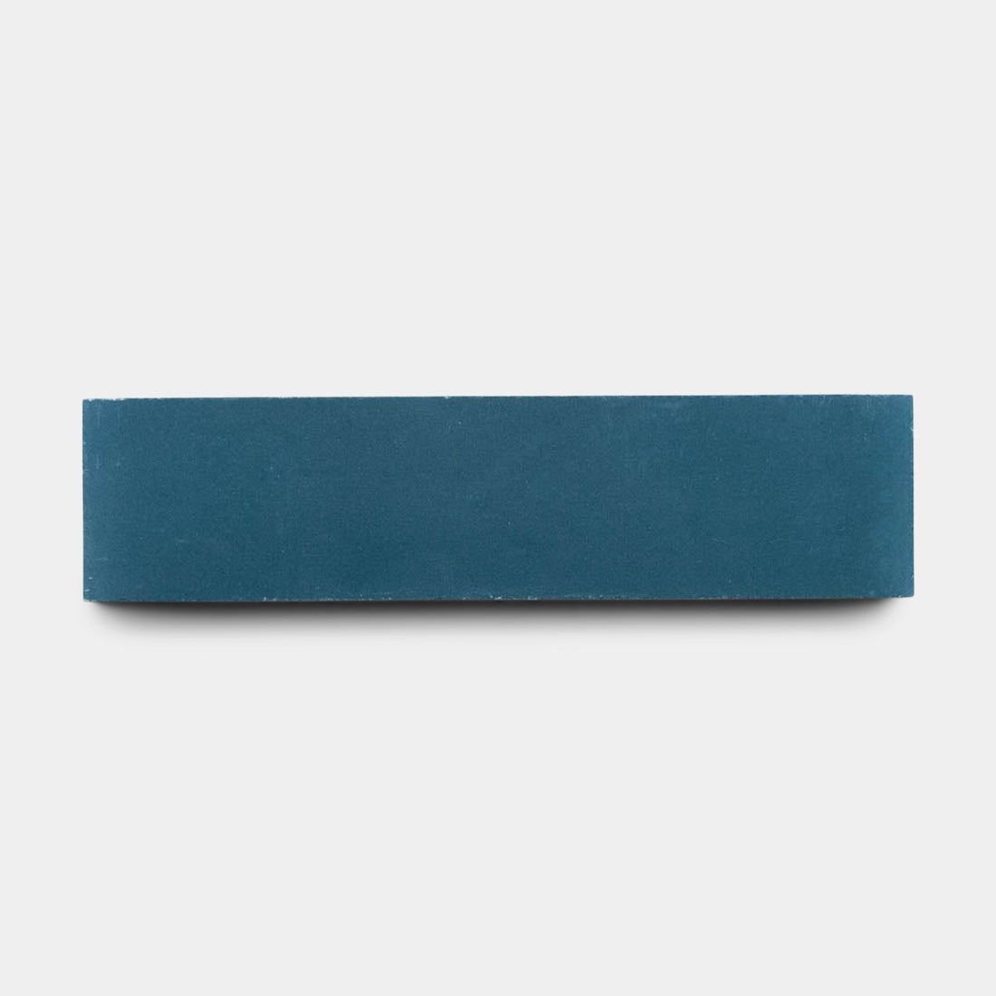 A vendor-unknown Midnight 2x8 sample tile, solid blue and rectangular, is handmade and centered on a plain white background, viewed from the side.