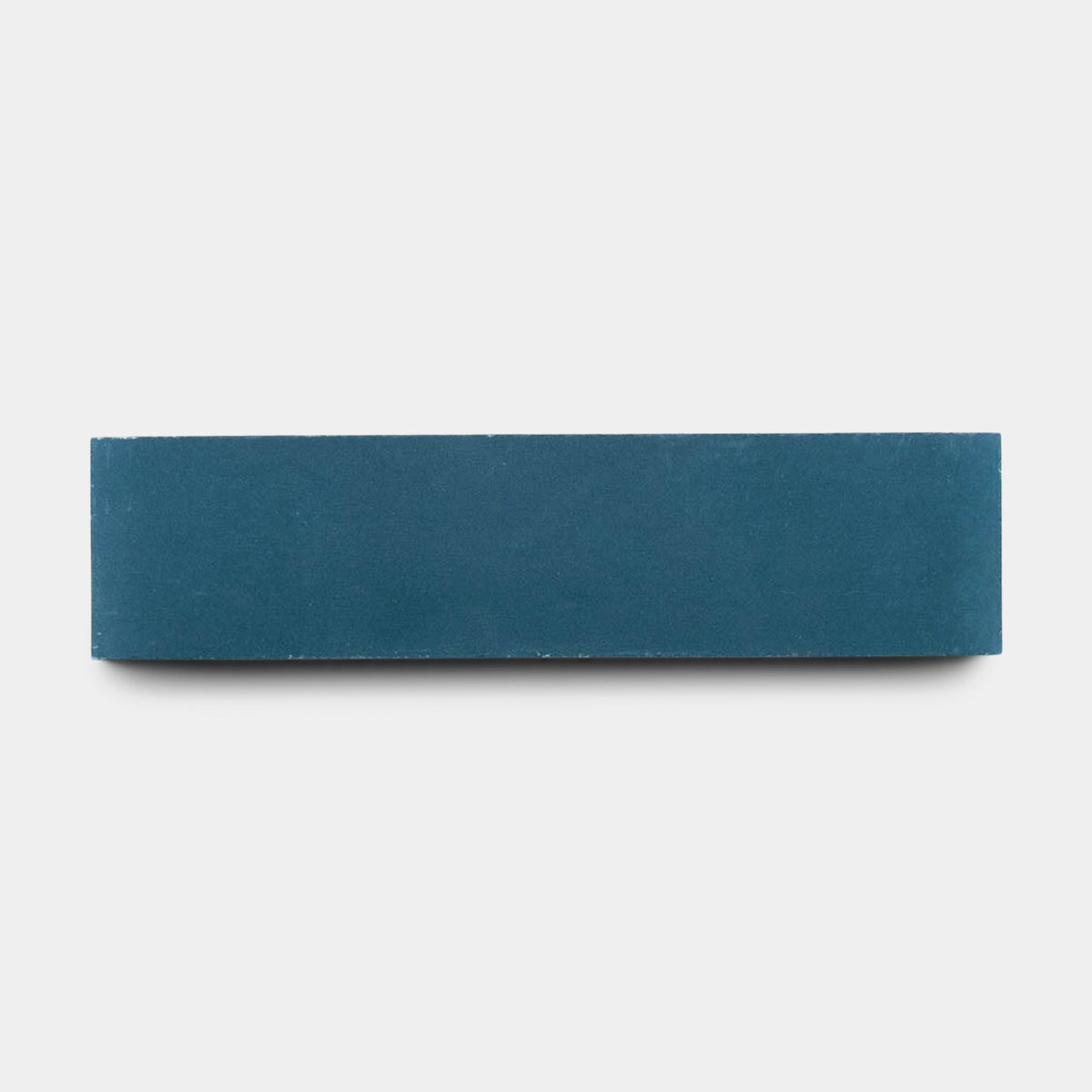 A vendor-unknown Midnight 2x8 sample tile, solid blue and rectangular, is handmade and centered on a plain white background, viewed from the side.
