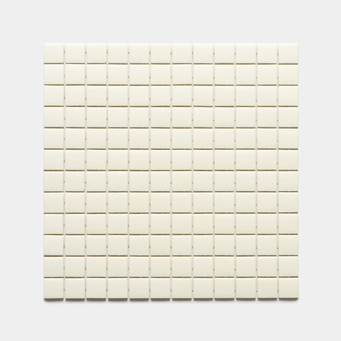 A square grid of Zia Tile’s Milk 1x1, Sample—small, cream-colored tiles—arranged evenly on a plain white background.