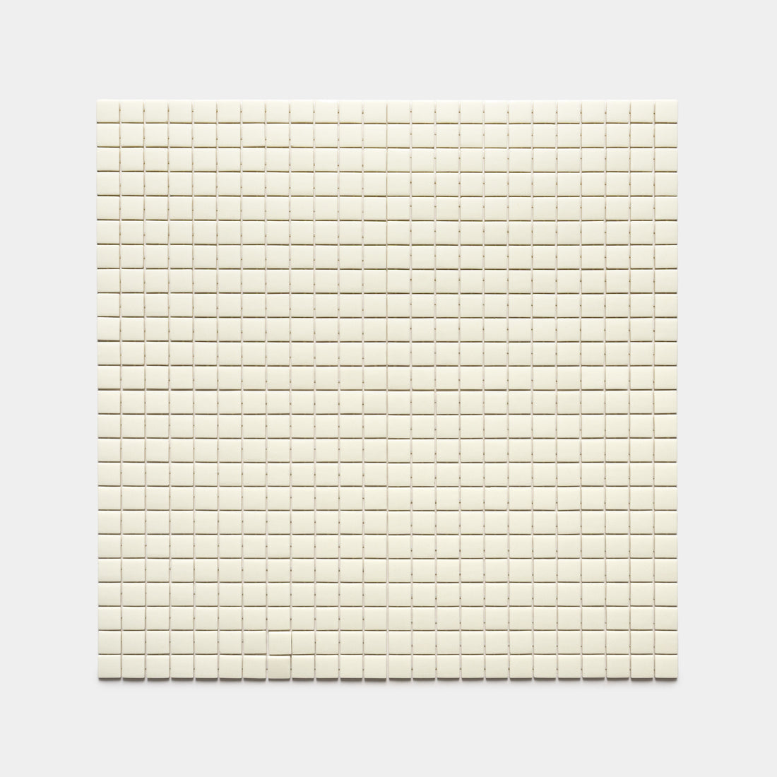 The Milk 1x1 tile by Zia Tile features a square grid of small, evenly spaced, off-white tiles arranged in neat rows and columns against a plain light gray background.