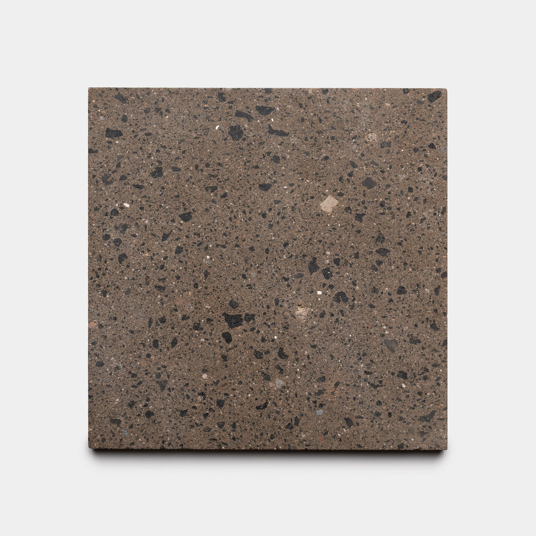 The Zia Tile Moab 12x12 is a square brown handmade tile featuring black and light brown speckles, inspired by traditional Moroccan designs, displayed on a plain white background.