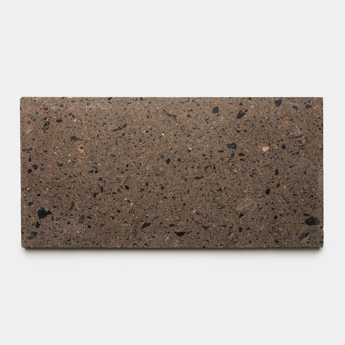 The Moab 12x24 tile by Zia Tile is a rectangular brown slab with black and dark brown speckles, shown handmade against a plain white background.