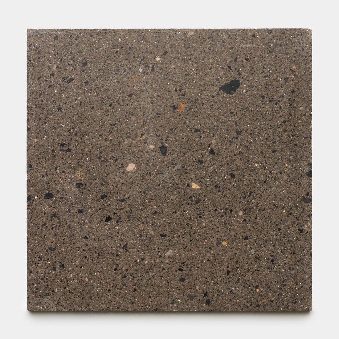 The Moab 24x24 tile by Zia Tile features a brownish-gray base with scattered black, beige, and white flecks that evoke natural stone or terrazzo, shown here against a plain white background.