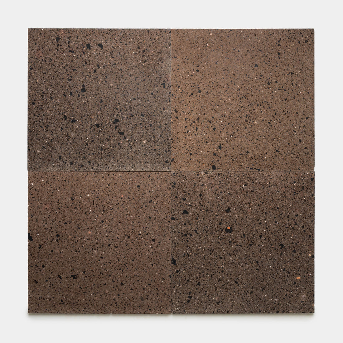 Four rectangular Moab 24x24 tiles by Zia Tile, featuring a brown volcanic stone finish with a speckled, porous texture, are arranged in a 2x2 grid on a white background, highlighting the artisanal craftsmanship characteristic of handmade tile designs from Zia Tile.