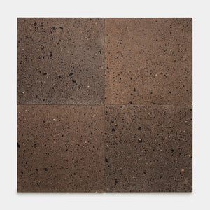 Four rectangular Moab 24x24 tiles by Zia Tile, featuring a brown volcanic stone finish with a speckled, porous texture, are arranged in a 2x2 grid on a white background, highlighting the artisanal craftsmanship characteristic of handmade tile designs from Zia Tile.
