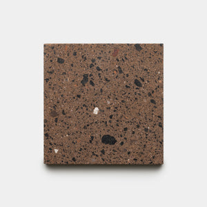 A sample of Zia Tile’s Moab 6x6 tile, featuring a square shape with a brown base and scattered black and gray speckles, displayed against a plain white background.