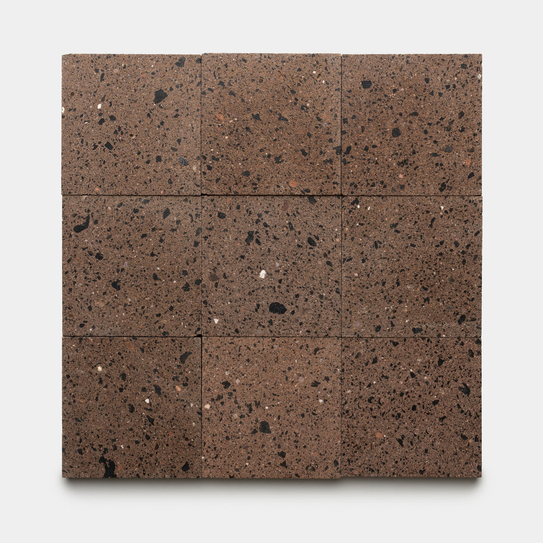 Nine square Moab 6x6 tiles in a brown volcanic stone finish, featuring black and white speckles, are arranged evenly in a three-by-three grid on a white background, highlighting the distinctive handmade craftsmanship by Zia Tile.