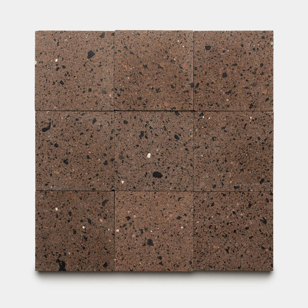 Nine square Moab 6x6 tiles in a brown volcanic stone finish, featuring black and white speckles, are arranged evenly in a three-by-three grid on a white background, highlighting the distinctive handmade craftsmanship by Zia Tile.