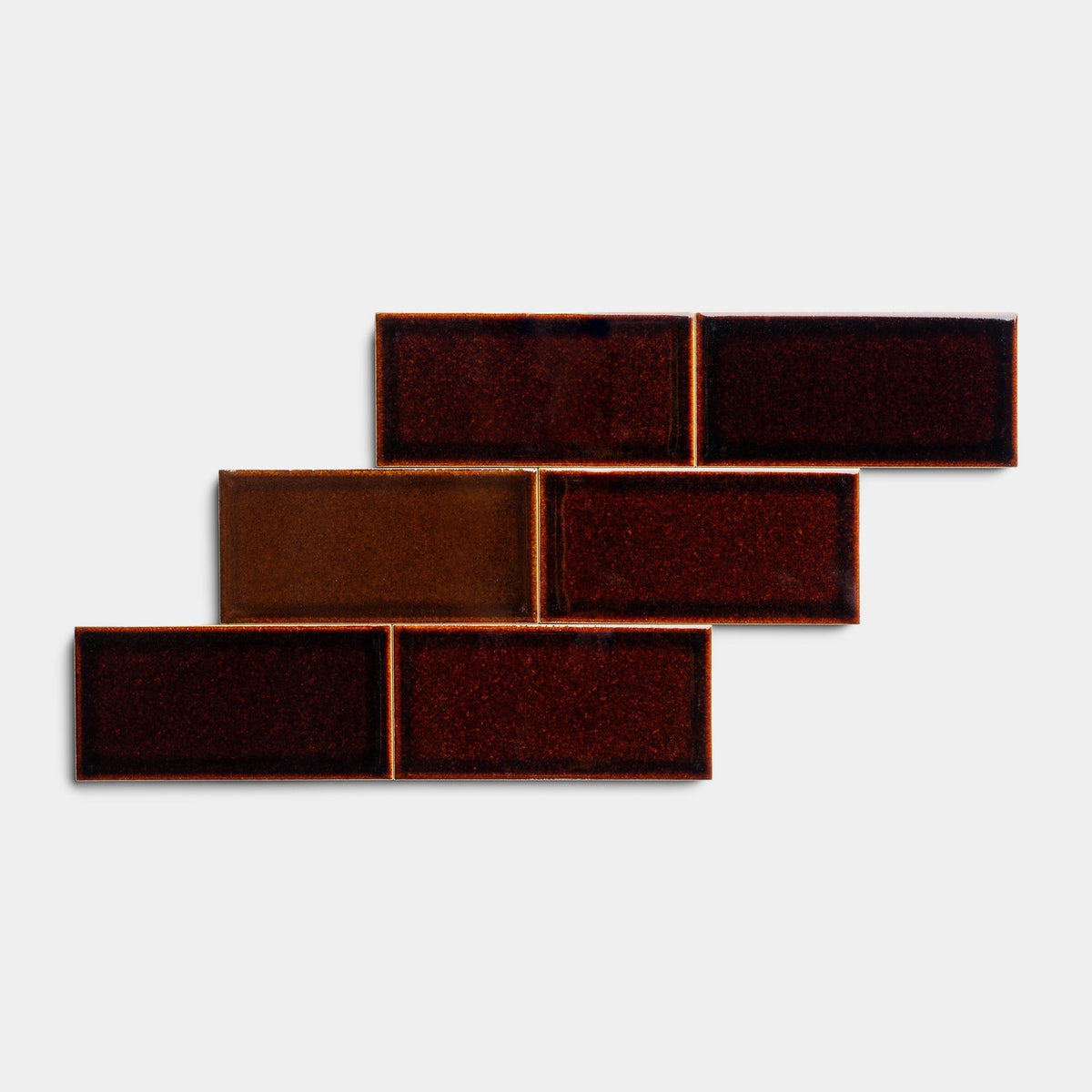 Six Molasses 2x4 sample tiles by Zia Tile, in glossy brown and reddish tones, are arranged in a staggered brick-like pattern against a plain white background.