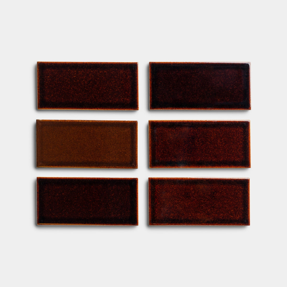 Six Molasses 2x4 ceramic tile samples by Zia Tile, in assorted brown and red tones, are arranged in two columns and three rows on a plain white background.