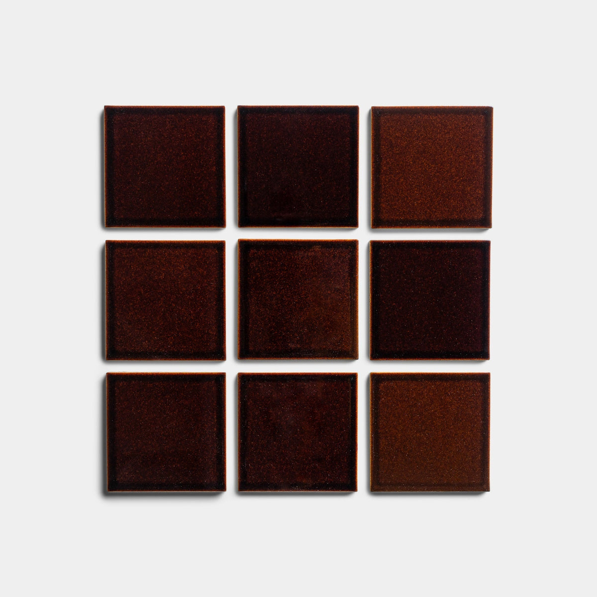 Nine Molasses 4x4 tiles by Zia Tile, dark brown with a slightly glossy finish and subtle color variations, are arranged in a three-by-three grid on a light gray background.