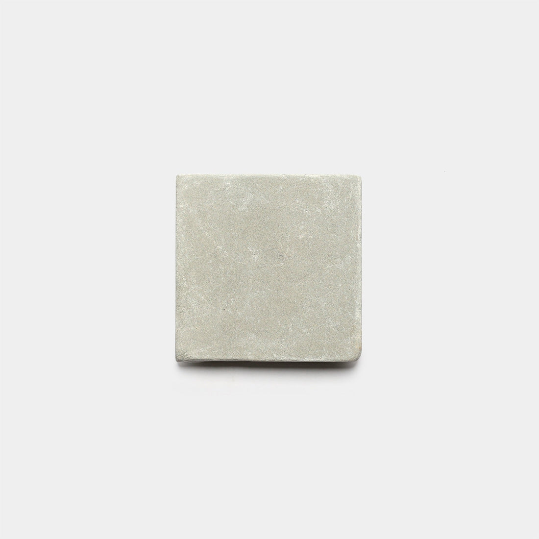 A single Monument 6x6 + Honed cement tile by Zia Tile, featuring a smooth matte finish in light gray, is displayed against a plain white background.