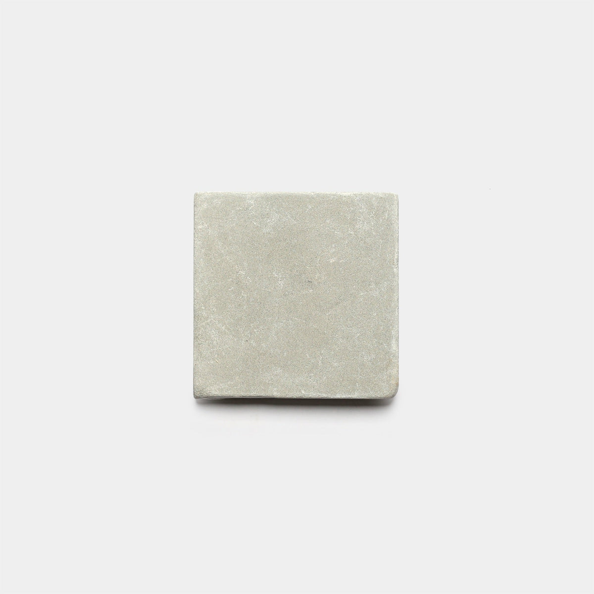 A single Monument 6x6 + Honed cement tile by Zia Tile, featuring a smooth matte finish in light gray, is displayed against a plain white background.