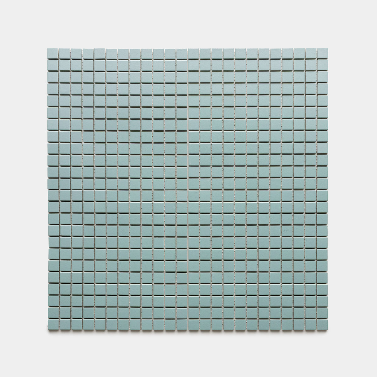 A rectangular grid of Zia Tile’s Moonlight 1x1 tiles in light blue is arranged evenly against a plain, light gray background.