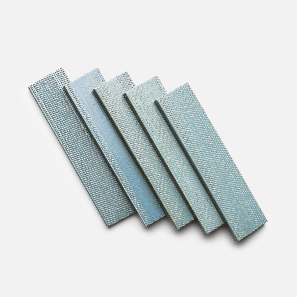 Five Morning Light + Etched rectangular tiles by Zia Tile are arranged in a fanned pattern on a white background.