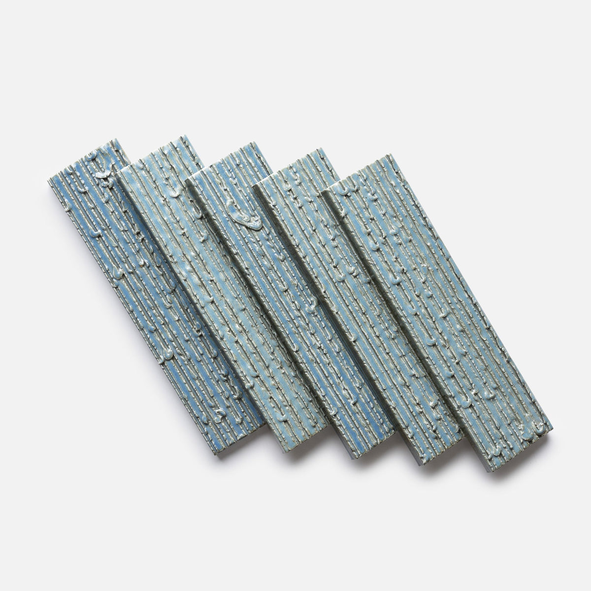 Five rectangular “Morning Light + Furrowed, Sample” panels by Zia Tile, each with a blue ridged surface and streaky paint details, are arranged diagonally and slightly overlapping on a plain white background.