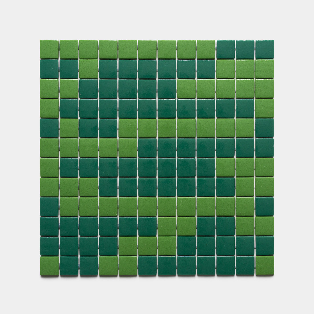 The Murano Clover + Jasper sample by Zia Tile features a rectangular grid of small square tiles in alternating light and dark green, creating a symmetrical geometric pattern on a white background.