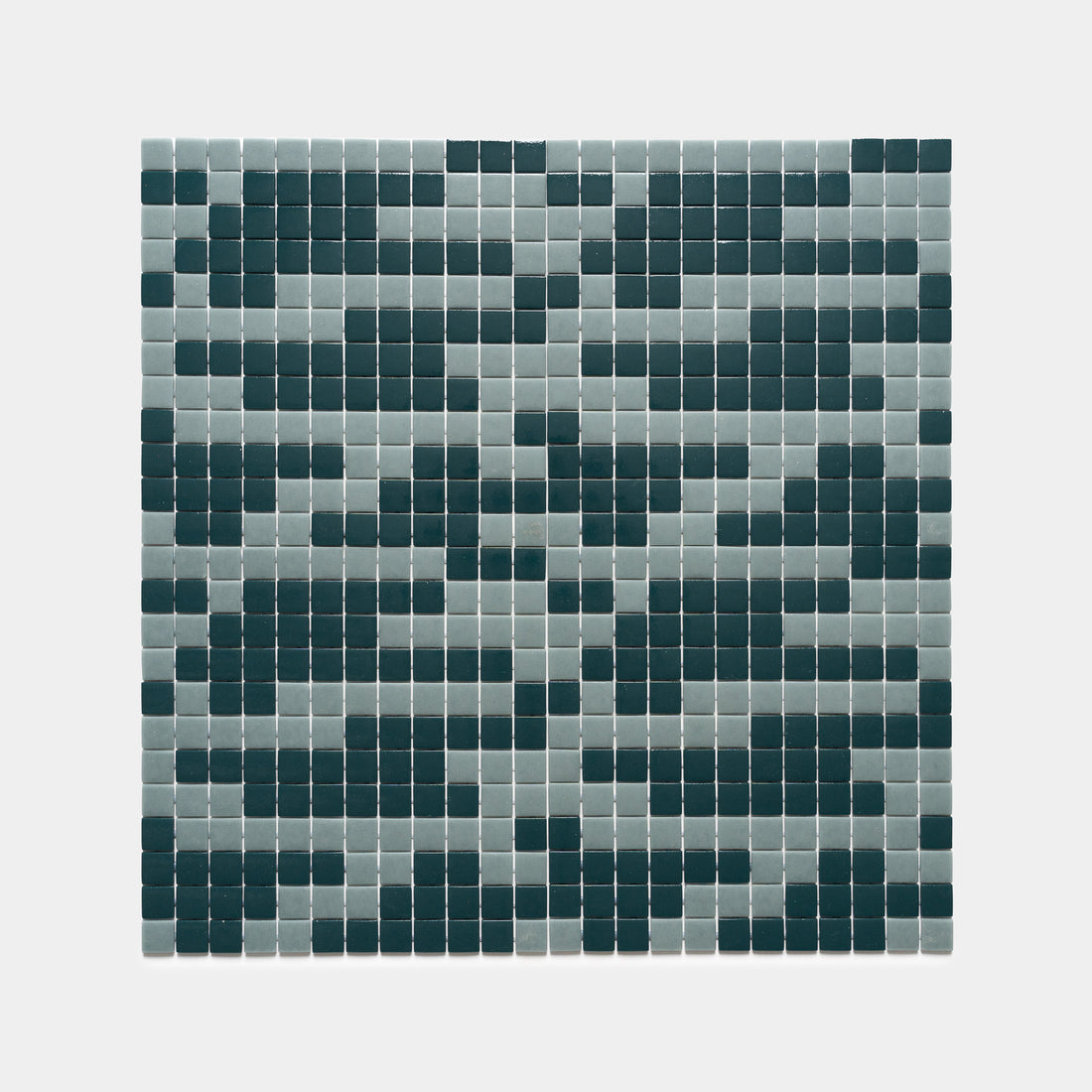 The Murano Marine Layer + Vespertine tiles by Zia Tile feature a grid of small squares in gray and dark green, creating a pixelated, abstract pattern on a crisp white background.