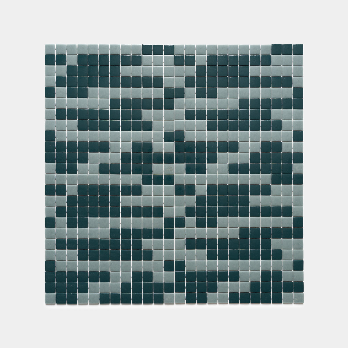 The Murano Marine Layer + Vespertine tiles by Zia Tile feature a grid of small squares in gray and dark green, creating a pixelated, abstract pattern on a crisp white background.