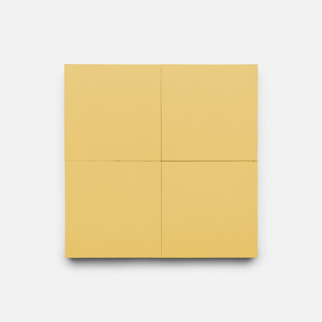 Mustard 4x4 by Zia Tile features four equal, slightly separated square panels in solid matte mustard yellow, evoking handmade tile, displayed against a plain white background.
