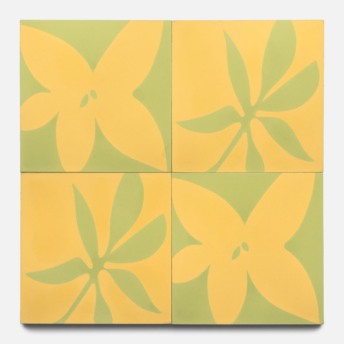 The Flora 8x8 Set Mustard + Lemongrass by Zia Tile features four square tiles with yellow and green abstract floral designs. Petals join at the center, creating a symmetrical, playful pattern across all tiles. Sample size available.