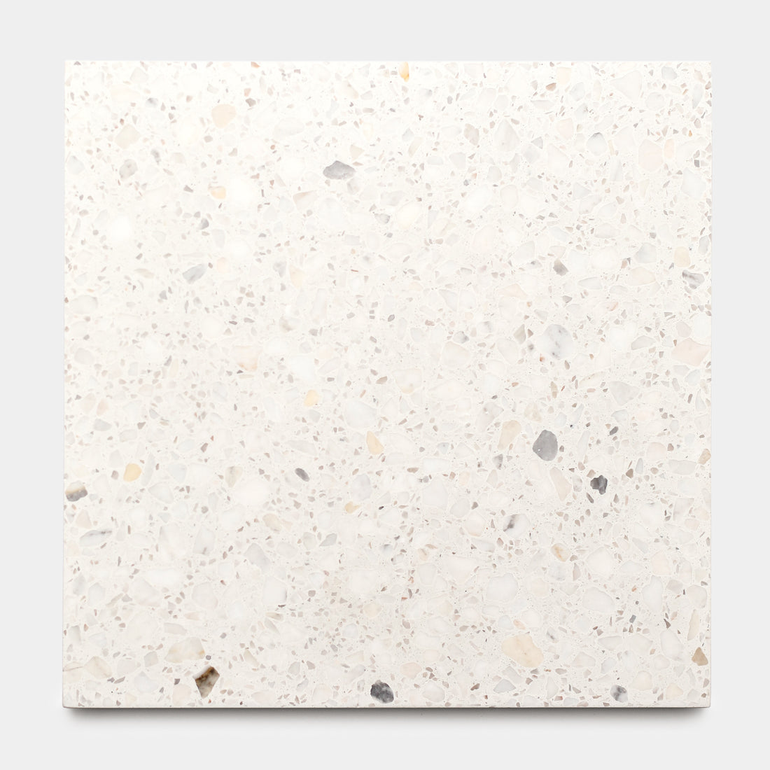 The Neutra 12x12 by Zia Tile is a square terrazzo cement tile with a white base and subtle gray, beige, and light brown flecks—ideal for kitchen backsplashes or stylish cement floors. Shown here on a plain light background.