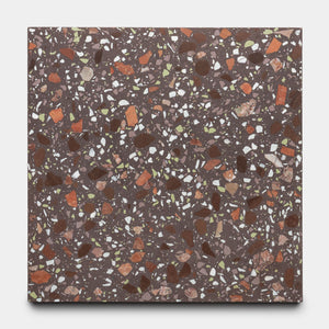 The Nocino 12x12 tile by Zia Tile features a dark brown base with white, red, orange, and green chips in varying sizes and shapes for a vibrant, speckled mosaic pattern.