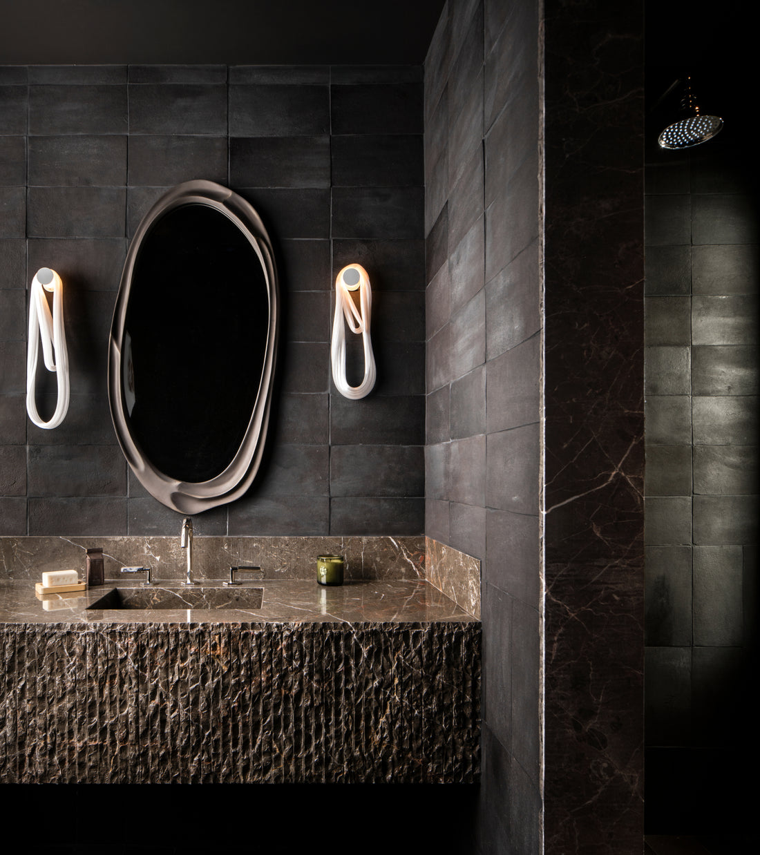 Bathroom vanity with a textured stone sink basin and brown marble countertop, set against charcoal-colored 6.5x13 Rectangle + Oscura handmade cotto tiles by Zia Tile.