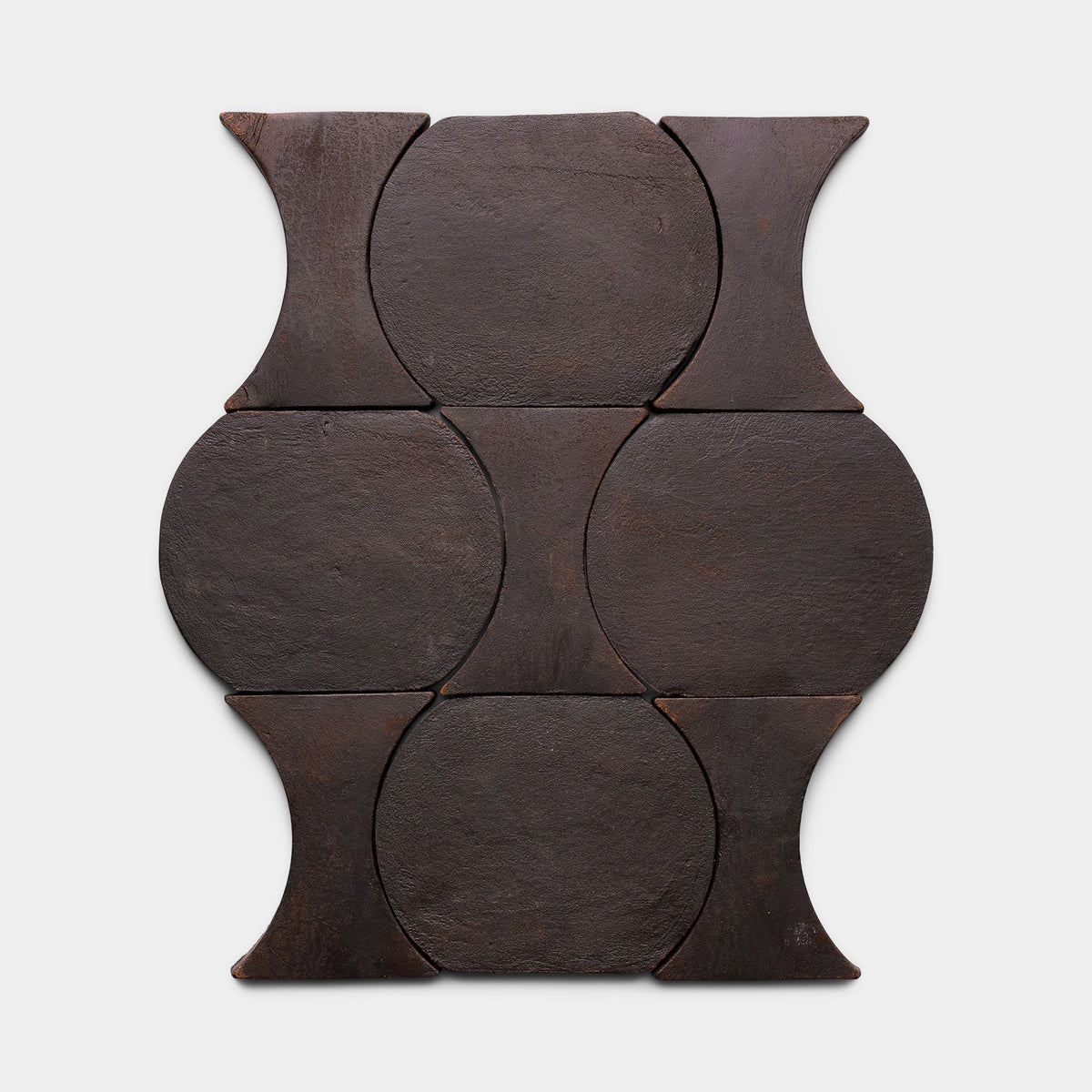 Six Oaxaca + Oscura tiles by Zia Tile are arranged in a geometric pattern of circular and hourglass shapes, creating a symmetrical, decorative design on a white background.