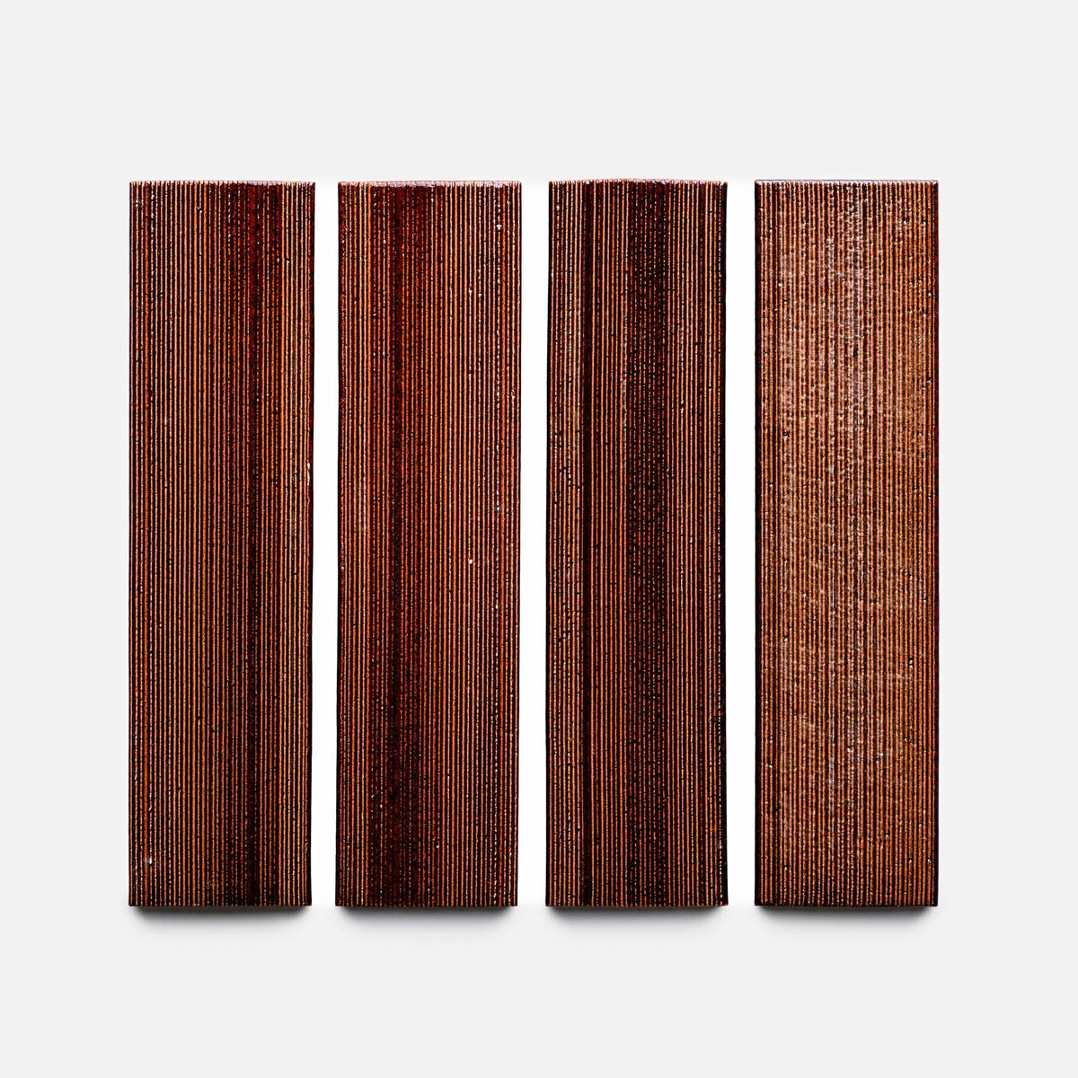 Four rectangular Oxblood + Etched wood samples from Zia Tile feature fine parallel grooves and a rich brown finish, arranged vertically side by side on a white background.