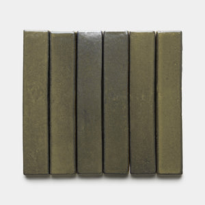 Six Oyamel Mini Bar tiles by Zia Tile, in olive-green ceramic with a smooth, glossy finish, are arranged vertically and evenly side by side against a plain white background.