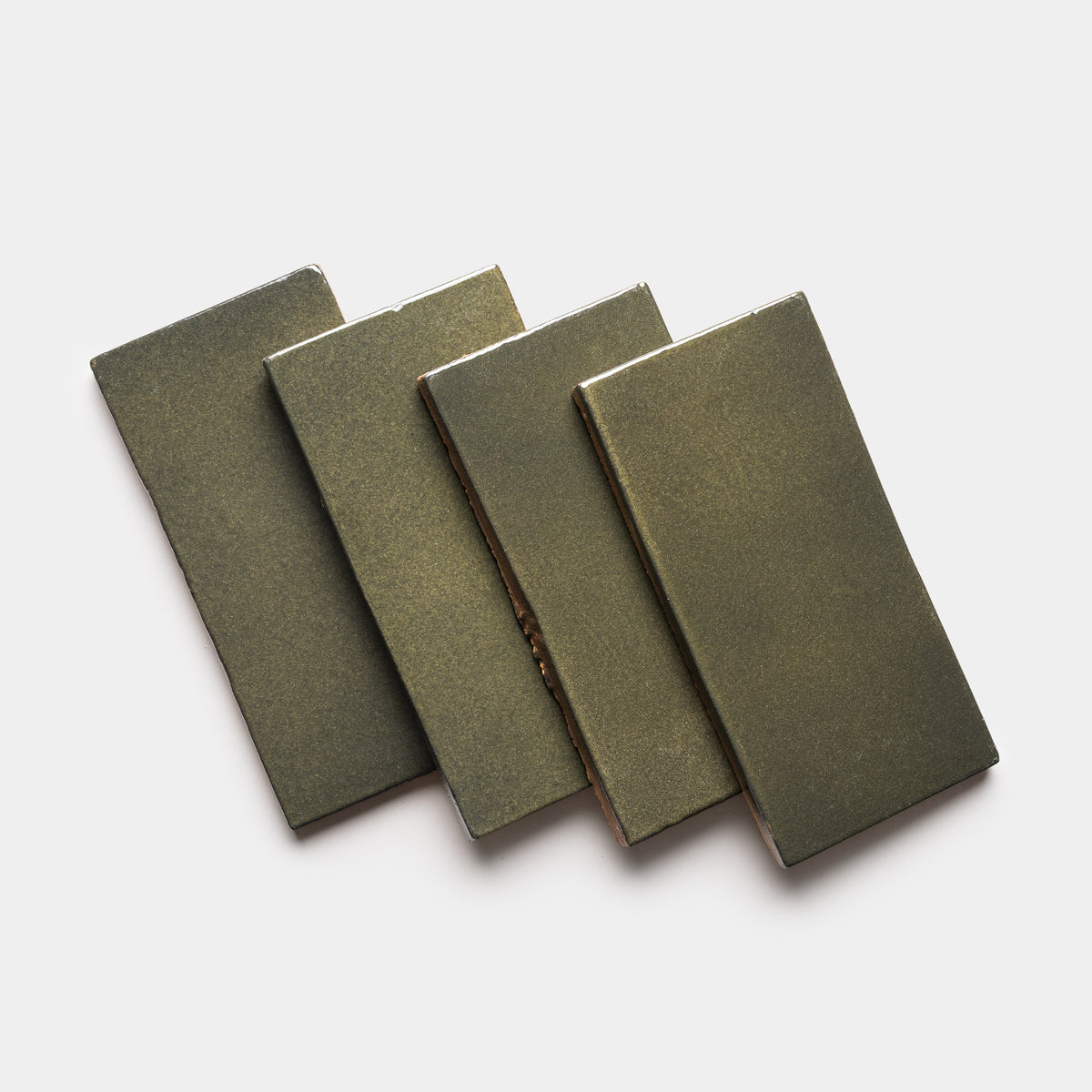 Four Oyamel 4x8 Rectangle tiles by Zia Tile, in olive-green ceramic with a smooth, glossy finish, are arranged in a staggered, overlapping pattern on a white background.