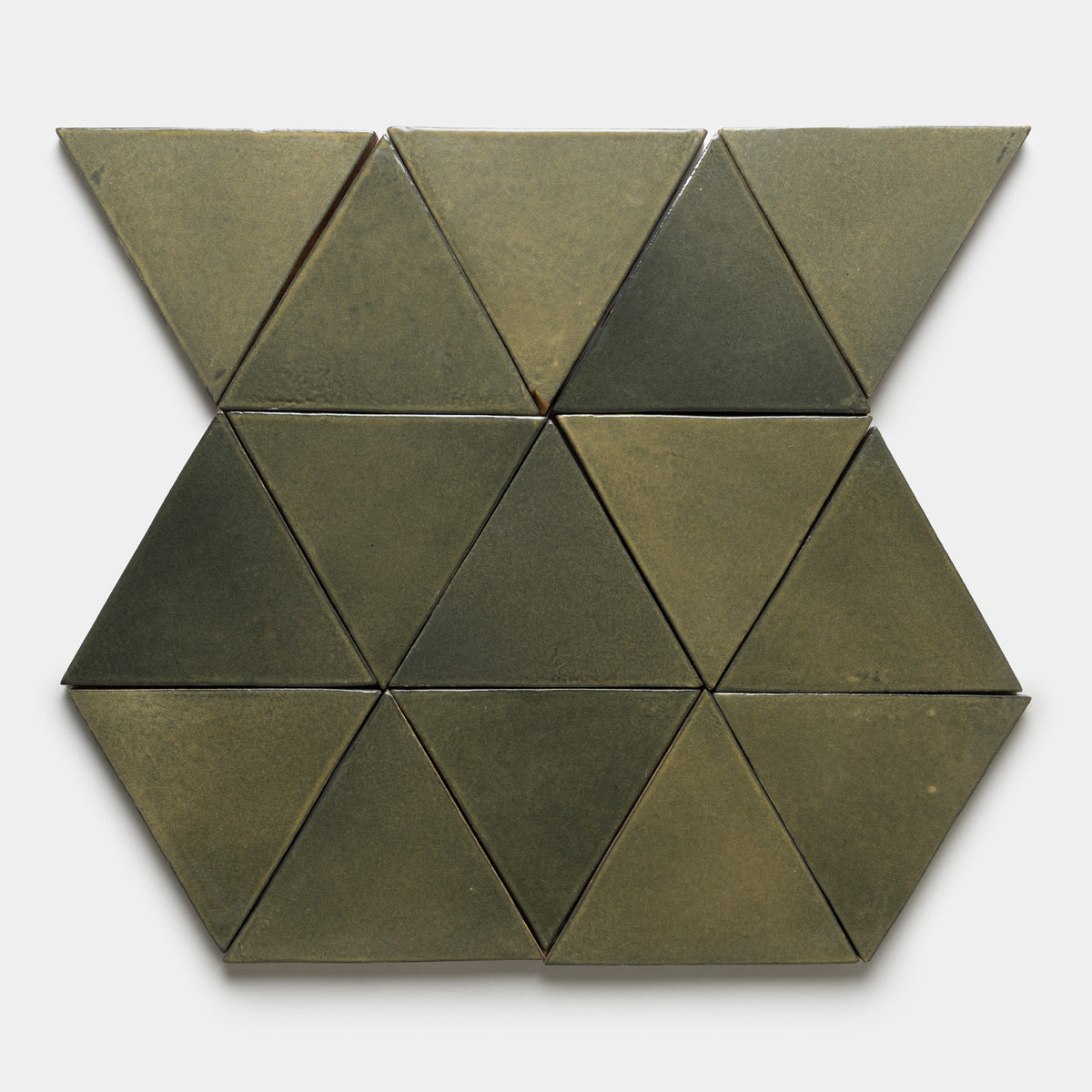 The Oyamel Triangle by Zia Tile features matte olive-green ceramic tiles, each an equilateral triangle, arranged in a symmetrical pattern on a plain white background.