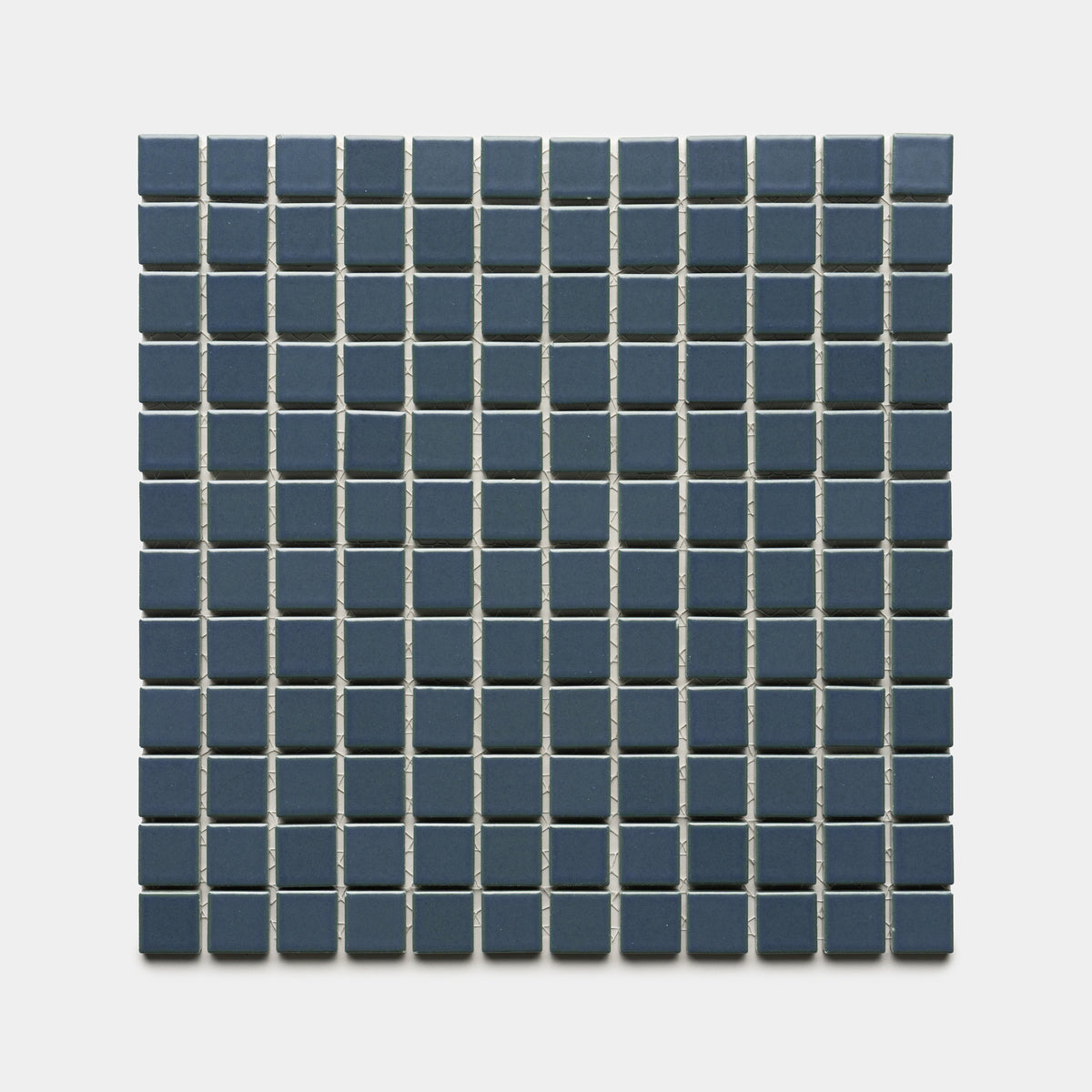 A square grid of Zia Tile's Pacific Blue 1x1 ceramic tiles features small, dark blue squares separated by thin white grout lines, arranged evenly against a plain light background.