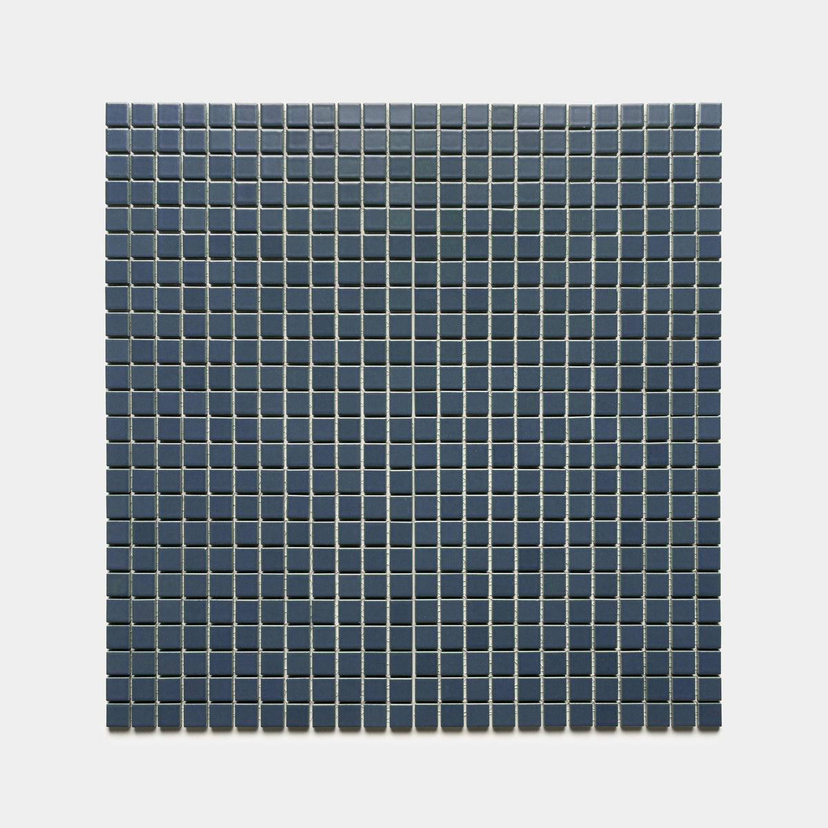 A square grid of Zia Tile's Pacific Blue 1x1 tiles, dark blue in color and divided by thin white grout lines, is arranged evenly against a light gray background.