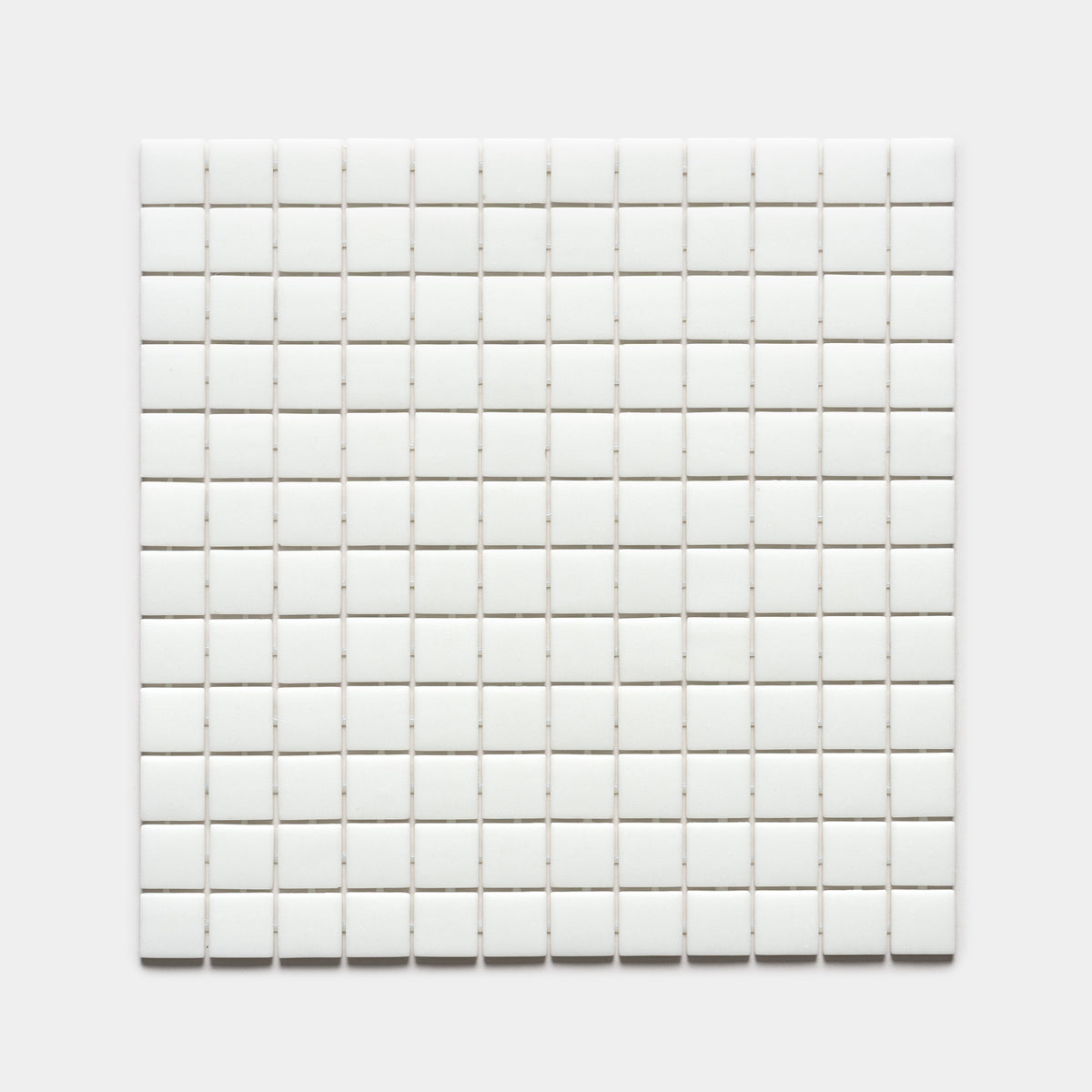 A grid of small, evenly spaced white 1x1 square tiles from Zia Tile’s Paperwhite collection is arranged in a square against a plain white background.