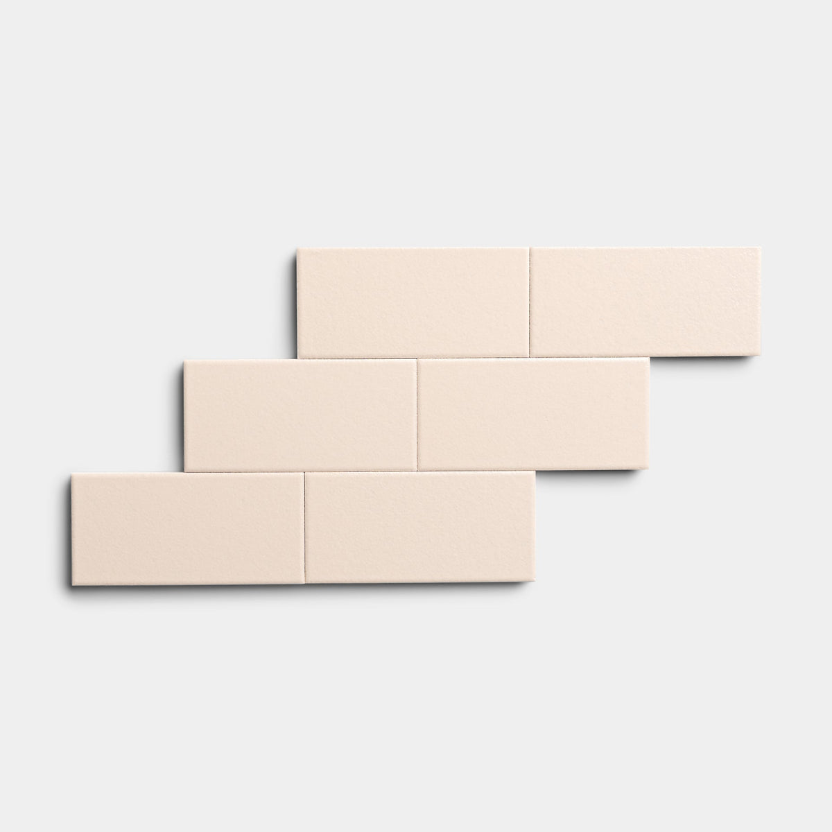 Six rectangular Peach Blossom 2x4 tiles by Zia Tile, light beige in color, are arranged in a staggered brick pattern on a plain white background.