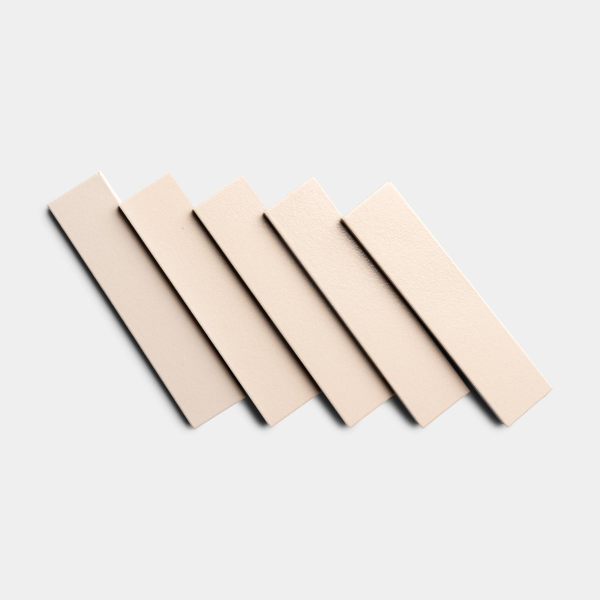 Five Peach Blossom 2x8 sample tiles by Zia Tile are arranged in a diagonal, overlapping pattern on a light gray background.