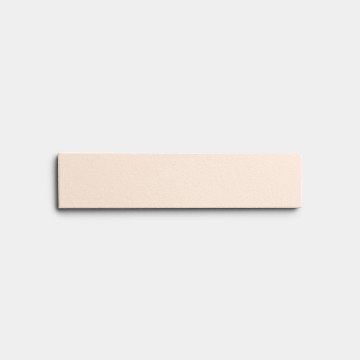 A Peach Blossom 2x8 ceramic tile sample from Zia Tile, in light beige, is centered against a plain white background.