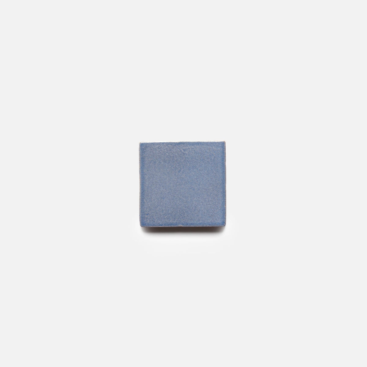 A single Pedregal 4x4 Square tile by Zia Tile, in blue and featuring a square shape, is centered against a plain white background.