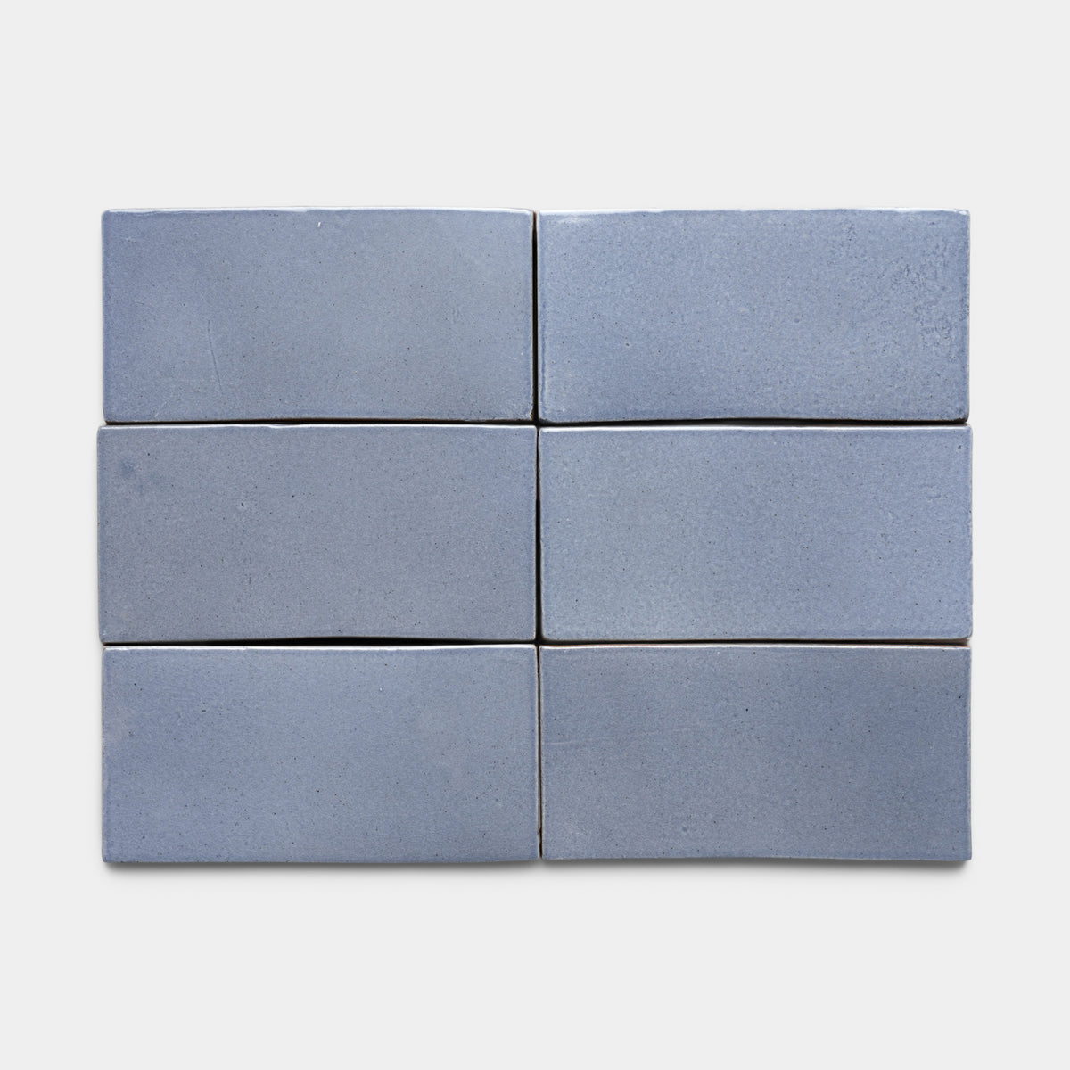 Six rectangular, smooth, blue-gray Pedregal 4x8 Rectangle tiles by Zia Tile are arranged in two rows of three on a plain white background.