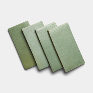 Four Peyote 4x8 Rectangle tiles by Zia Tile, in green ceramic, are arranged in an overlapping, slightly staggered pattern on a plain white background.